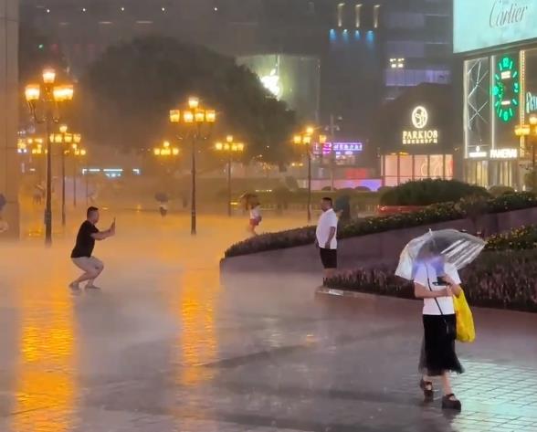 游客冒雨在解放碑拍照 网友：渝中（雨中）真爱粉